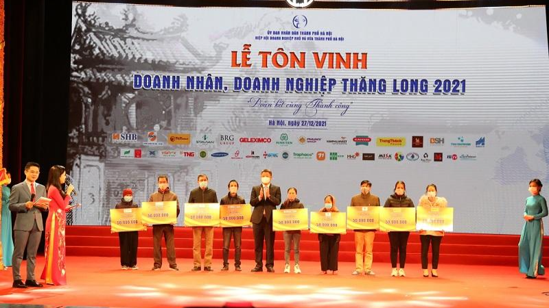 Phó Chủ tịch UBND TP Hà Nội đại diện DN trao hỗ trợ cho các hộ nghèo.