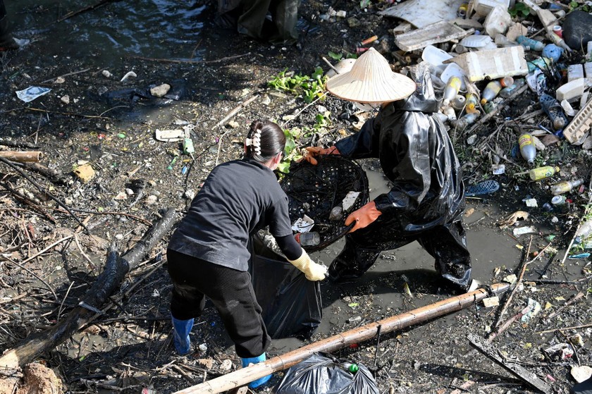 Các bạn trẻ miệt mài vớt rác trên dòng sông ô nhiễm. (Nguồn: Facebook Hà Nội Xanh) 