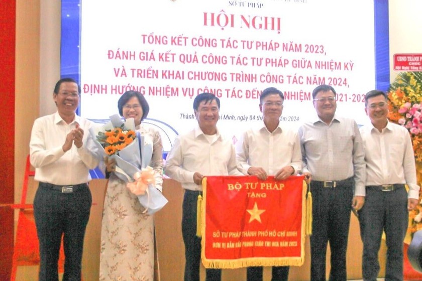 Bộ trưởng Bộ Tư pháp Lê Thành Long trao Cờ đơn vị dẫn đầu phong trào thi đua năm 2023 cho Sở Tư pháp TP HCM. (Nguồn ảnh: Sở Tư pháp TP HCM)