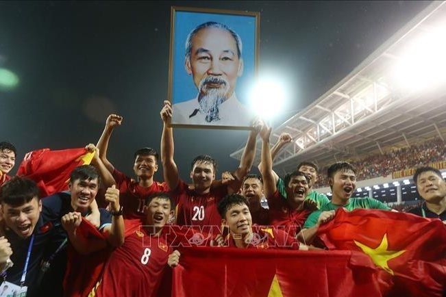 Các cầu thủ U23 Việt Nam giương cao ảnh Bác Hồ vui mừng chiến thắng sau khi giành tấm huy chương Vàng tại SEA Games 31, trên SVĐ quốc gia Mỹ Đình (Hà Nội). (Ảnh: TTXVN).