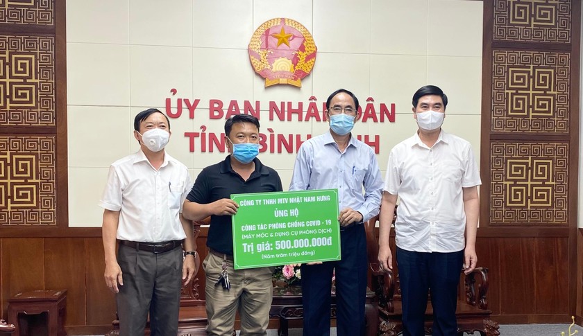 Ông Ngô Trương Khánh (áo đen) trao bảng biểu trưng hỗ trợ cho công tác phòng, chống dịch COVID-19 ở Bình Định. Ảnh: Cổng TTĐT Bình Định.