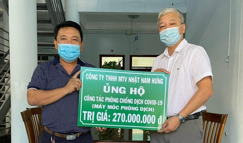 Ông Ngô Trương Khánh (trái) trao bảng biểu trưng hỗ trợ cho công tác phòng, chống dịch COVID-19 ở Bình Định.