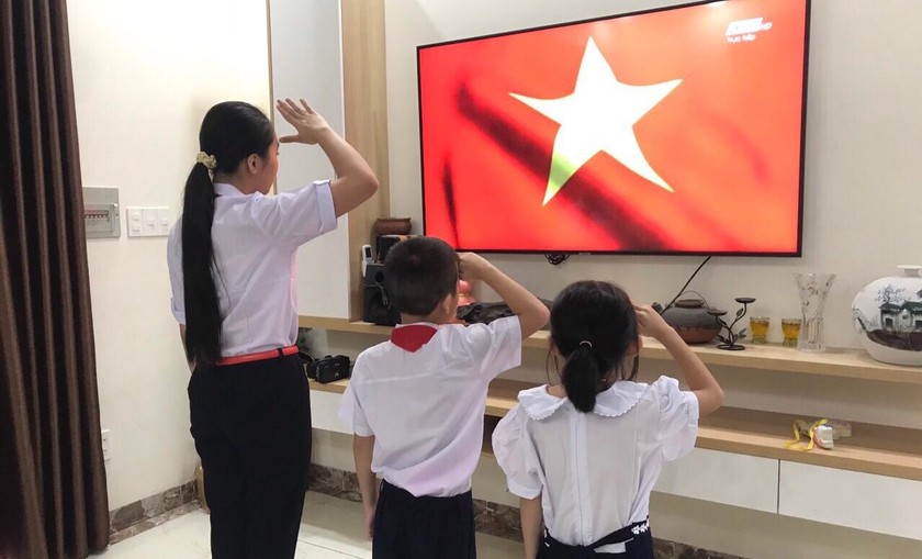 Các em học sinh tại TP Nha Trang chào cờ trong lễ Khai giảng năm học mới tại nhà. Ảnh: Diễm Hương 