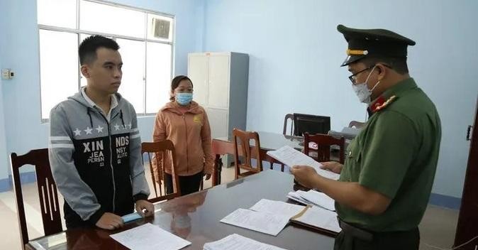 Cơ quan công an đọc lệnh khởi tố bị can Lâm Văn Bình (trái). 