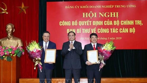 Ông Phạm Minh Chính trao quyết định của Bộ Chính trị cho ông  Y Thanh Hà Niê Kđăm (bên phải), và ông Trần Sỹ Thanh (bên trái). Ảnh: TTXVN