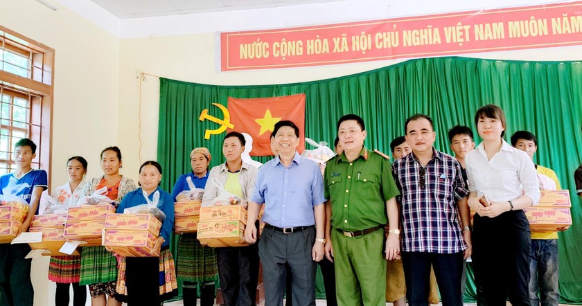 Đại diện Tập đoàn Phượng Hoàng và Công an huyện Mộc Châu trao quà cho người dân bản Pha Đón.