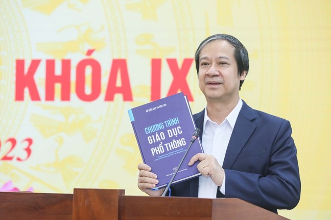 Bộ trưởng Bộ Giáo dục và Đào tạo Nguyễn Kim Sơn giới thiệu cuốn sách Chương trình GDPT với các đại biểu tham dự hội nghị.