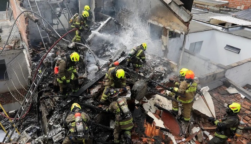 Lực lượng cứu hộ làm nhiệm vụ tại hiện trường máy bay lao xuống khu dân cư ở Medellin, Colombia, ngày 21/11. Ảnh: AP.