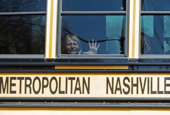 Một trẻ em khóc khi ngồi trên xe buýt rời trường Covenant. Ảnh: Reuters.
