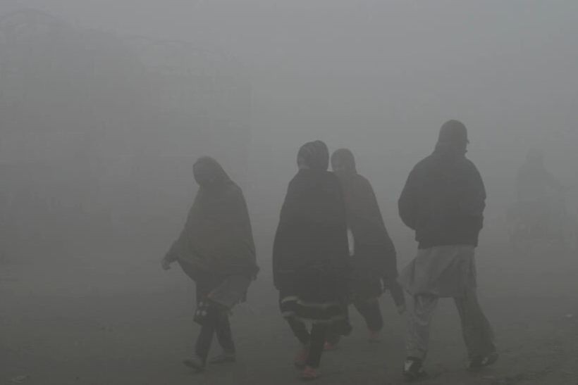 Người dân đi bộ trong làn sương mù dày đặc ở ngoại ô Lahore vào ngày 14/12/2023. Ảnh: AFP.