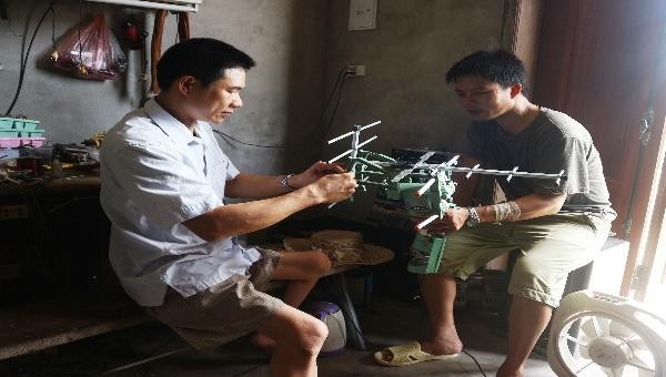 Anh Vinh (bìa phải) đang sửa chữa đồ cho khách
