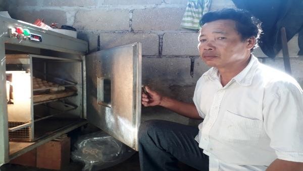 Cựu chiến binh Phạm Huy Chương bên mô hình nuôi gà và máy ấp trứng