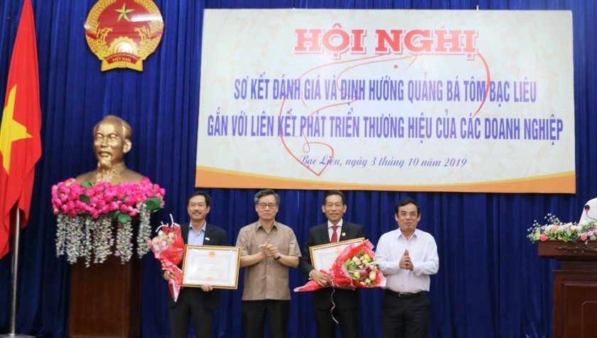 Ông Nguyễn Quang Dương - Ủy viên TW Đảng, Bí thư Tỉnh ủy Bạc Liêu và ông Dương Thành Trung - Chủ tịch UBND tỉnh trao bằng khen cho các tập thể có thành tích trong việc quảng bá và phát triển thương hiệu tôm Bạc Liêu