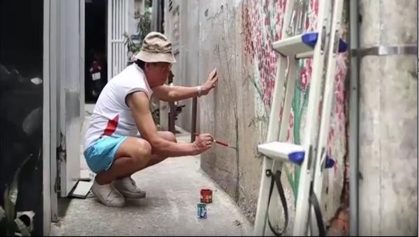 Họa sĩ Nguyễn Văn Minh cặm cụi, say mê sáng tác những bức tranh tường