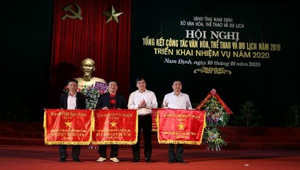 Phó Chủ tịch UBND tỉnh Trần Lê Đoài trao cờ của UBND tỉnh Nam Định tặng các đơn vị dẫn đầu phong trào thi đua năm 2019 - Ảnh Khánh Dũng