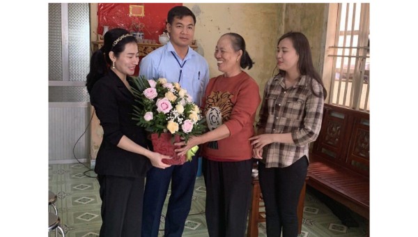 Bác sĩ Bàn Thị Cảnh (thứ 3 từ trái sang) và con gái Đặng Thị Ngà (bìa phải) nhận hoa chúc mừng ngày thầy thuốc VN của đoàn cán bộ địa phương
