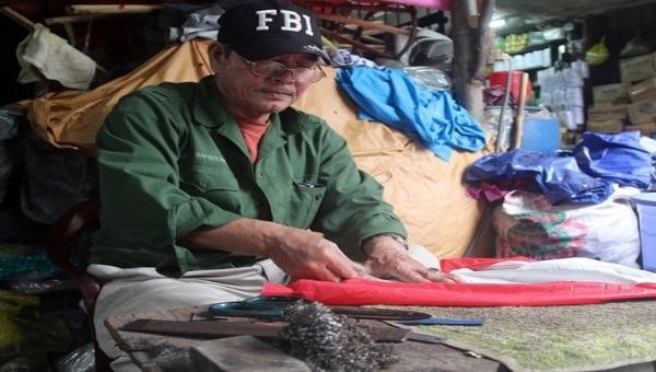 Chú Lâm Thành Thuận là người duy nhất còn làm nghề vá áo mưa tại chợ Đông Ba. (Ảnh: Kênh 14). 