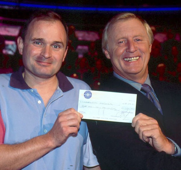 Thiếu tá Charles nhận tấm séc 1 triệu bảng từ MC Chris Tarrant. 