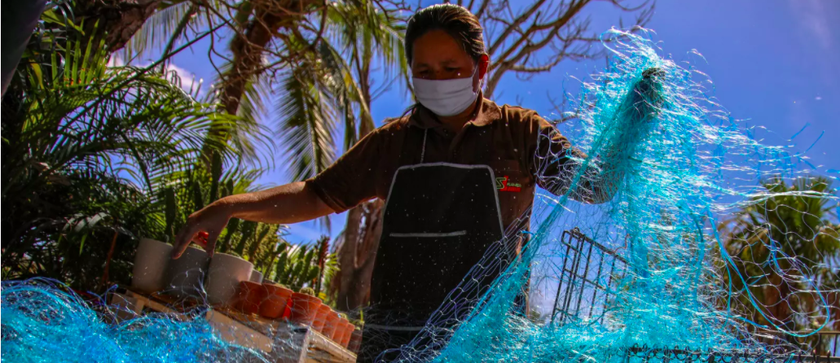 Tái chế lưới đánh cá bỏ đi thành mặt nạ, chai khử trùng chống dịch. (Ảnh: Reuters).