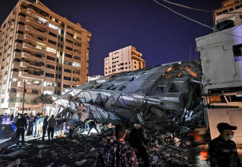 Người dân tập trung tại một tòa nhà bị sập sau cuộc không kích của Israel vào thành phố Gaza.
