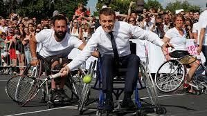 Bức ảnh chụp Tổng thống Pháp Emmanuel Macron ngồi trên xe lăn chơi quần vợt với các vận động viên khuyết tật. 