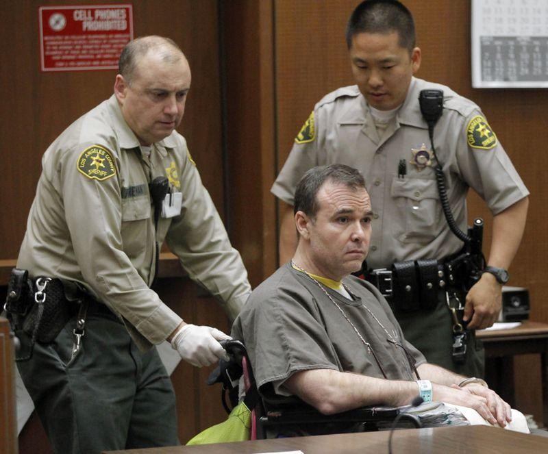 David Viens (giữa) ngồi xe lăn khi được áp giải đến tòa.