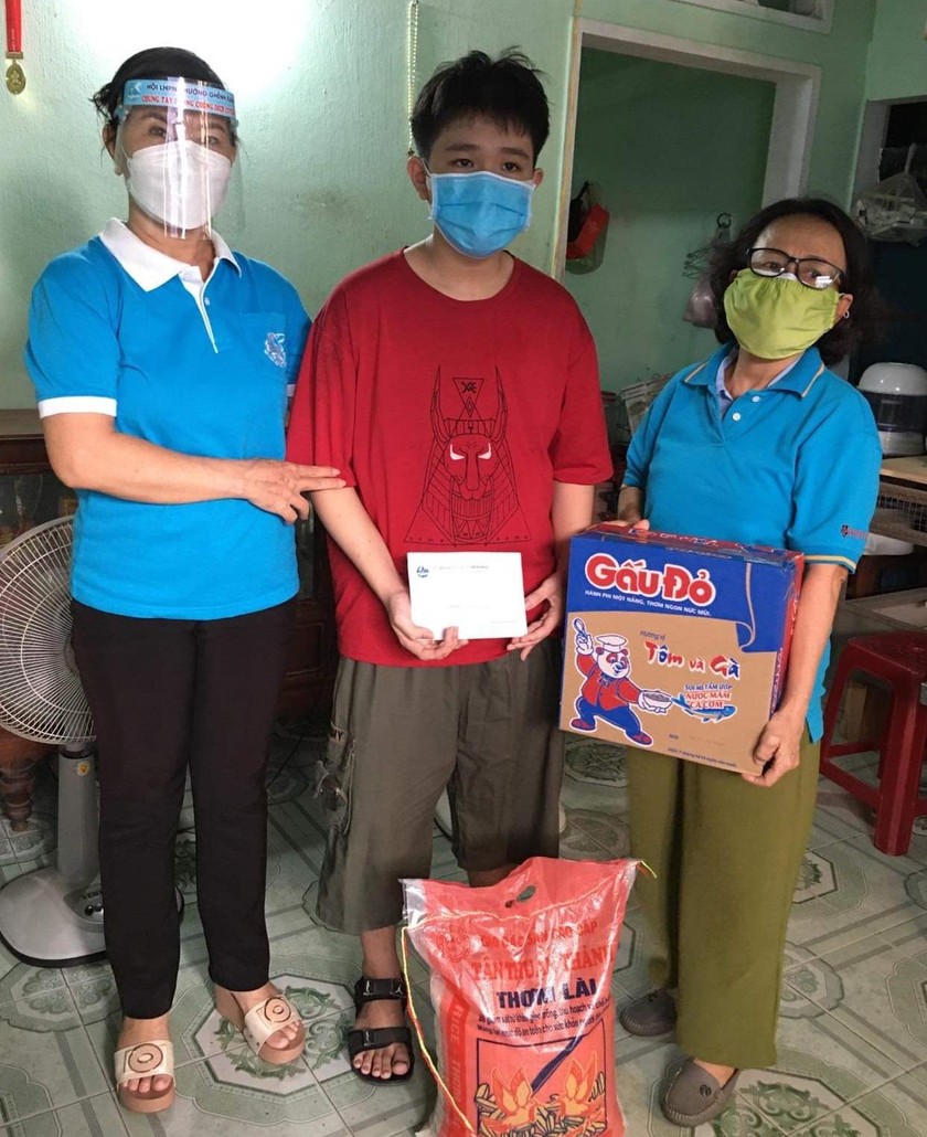 Bà Nguyễn Thị Sáu (trái) tặng quà cho người dân khó khăn.