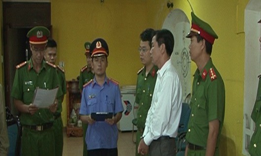 Ông Lê Hữu Lam (áo trắng) nghe đọc lệnh bắt