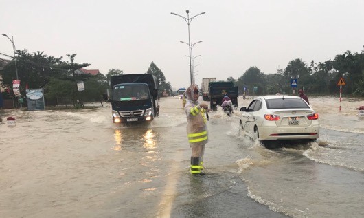 Các chiến sỹ CSGT dầm mưa điều tiết giao thông qua đoạn ngập lụt.