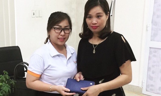 Chị Lê Thị Minh Tuyền (áo trắng) đại diện công ty trao trả tài sản cho khách bỏ quên.