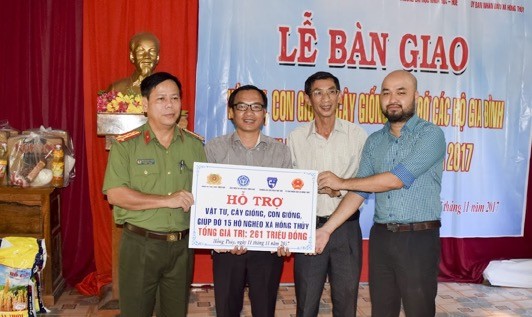 Đại tá Nguyễn Văn Thanh (Bìa trái) trao vật tư cho đại diện chính quyền địa phương 