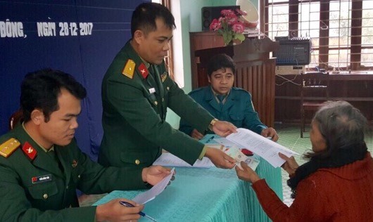 Cán bộ Ban CHQS huyện Nam Đông trao giấy chứng nhận và tiền trợ cấp cho các đối tượng.