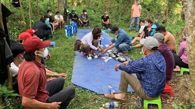 Các đối tượng tụ tập đánh bạc giữa rừng keo ở hồ Phú Ninh. (Ảnh: CA).