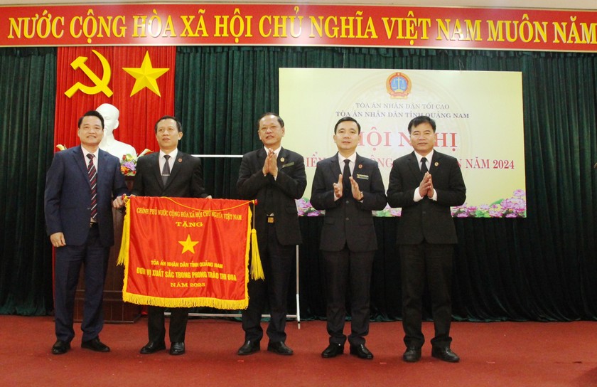 Thừa ủy quyền, ông Nguyễn Hồng Nam (thứ nhất, bên trái) trao Cờ thi đua của Chính phủ cho TAND Quảng Nam.