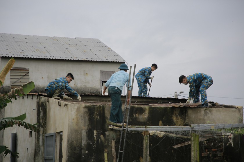 Lực lượng bộ đội tiến hành sửa chữa lại nhà hư hỏng cho người dân. 