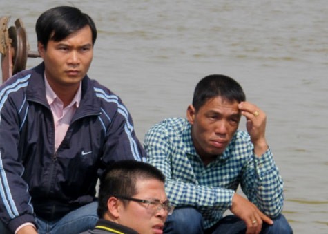 Anh Nguyễn Hữu Huy, chồng chị Huyền (ngoài cùng bên phải), trên thuyền tìm kiếm thi thể vợ trưa 26/10.