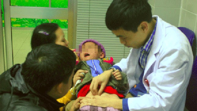 Bác sĩ Nguyễn Hoài Bắc đang khám cho một bé trai 3 tuổi bị dị tật lỗ tiểu lệch thấp. Ảnh: MT.