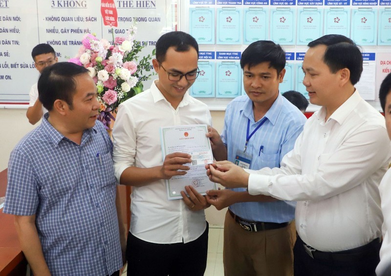 Đại diện BHXHVN trao thẻ bảo hiểm y tế cho gia đình bé Đinh Bảo N. (huyện Thanh Liêm, tỉnh Hà Nam) - là trẻ em đầu tiên được cấp giấy khai sinh, thẻ bảo hiểm y tế, đăng ký thường trú thông qua dịch vụ công liên thông.