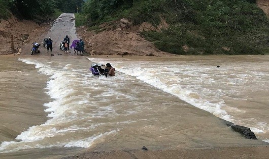 Mặc dù tại cầu tràn nước chảy xiết nhưng 4 thanh niên vẫn liều mình đưa xe máy vượt qua (ảnh Đoàn Nhật Thái)