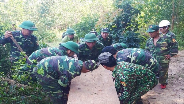 Các cán bộ, chiến sỹ Đồn Biên phòng Cửa khẩu Quốc tế La Lay vận chuyển số gỗ vừa phát hiện được về đơn vị (ảnh: QH)