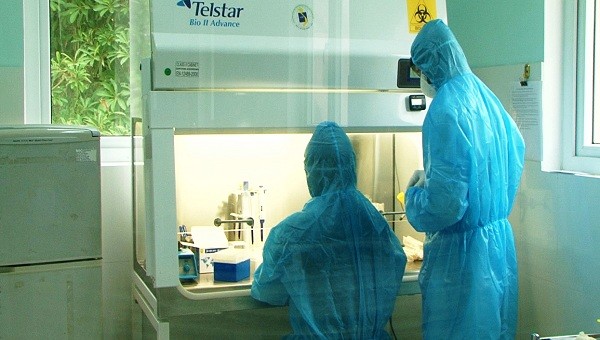 Các cán bộ y tế của Trung tâm Kiểm soát bệnh tật tỉnh Quảng Trị thực hiện xét nghiệm trên hệ thống máy (ảnh: TL) 