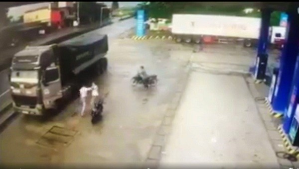 Tài xế xe tải lao xuống đường đánh người đàn ông đi xe máy sau khi lời qua tiếng lại (ảnh cắt từ video)