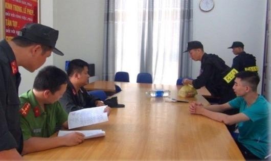Lực lượng Cảnh sát Cơ động bàn giao đối tượng Đỗ Minh Hiếu (áo xanh, bên phải) cho Công an phường Đông Hương. 