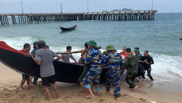 Lực lượng chức năng lai dắt đưa thuyền của vợ chồng anh Thành vào bờ.