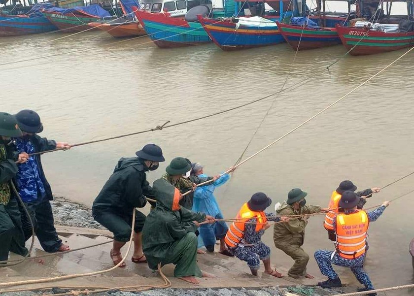 Lực lượng chức năng giúp ngư dân kéo tàu thuyền vào nơi trú ẩn tại Cửa Sót, huyện Lộc Hà (Hà Tĩnh).