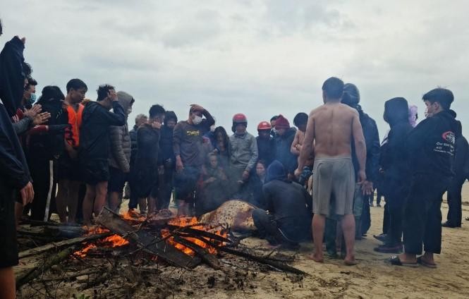 Người dân địa phương đỏ lửa sưởi ấm cho các ngư dân gặp nạn vừa được cứu đưa vào bờ.