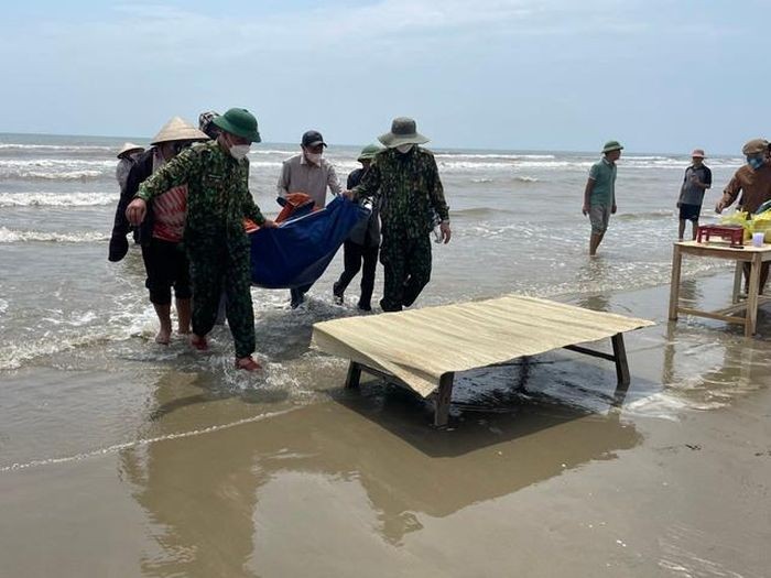 Lực lượng chức năng cùng người dân đưa thi thể nạn anh Nguyễn Văn S. vào bờ.