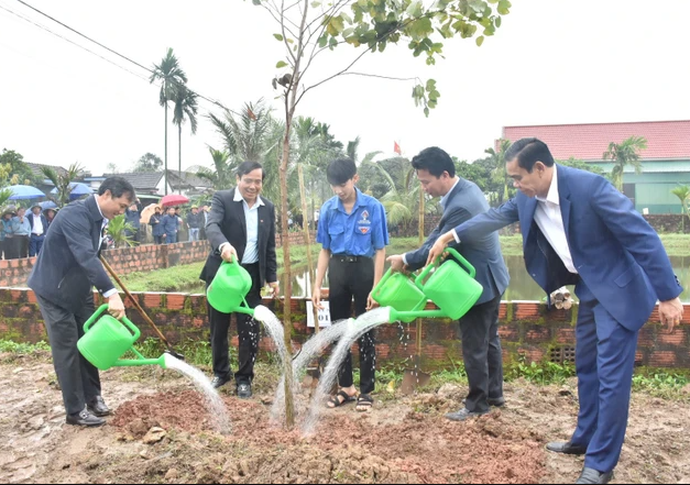 Bộ trưởng Bộ TN&MT Đặng Quốc Khánh và lãnh đạo tỉnh Hà Tĩnh tham gia trồng cây hoa ban tại xã Cẩm Quan, huyện Cẩm Xuyên. Ảnh: PV