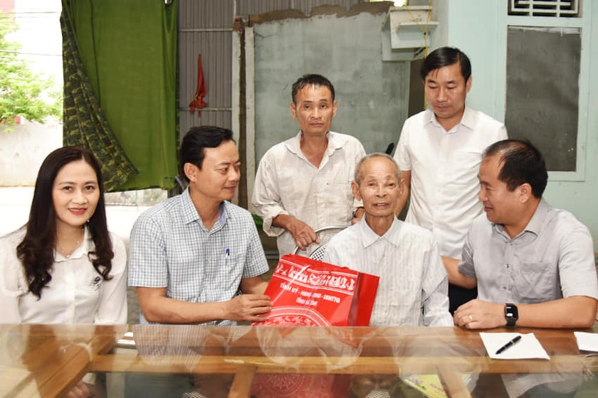 Ông Hà Văn Hùng, Trưởng ban Tuyên giáo Tỉnh ủy Hà Tĩnh và lãnh đạo huyện Lộc Hà tặng quà cho các cựu chiến binh ở thị trấn Lộc Hà. Ảnh: PV