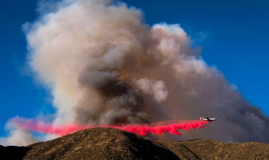 Một máy bay thả chất làm chậm cháy xuống đám cháy ở California.